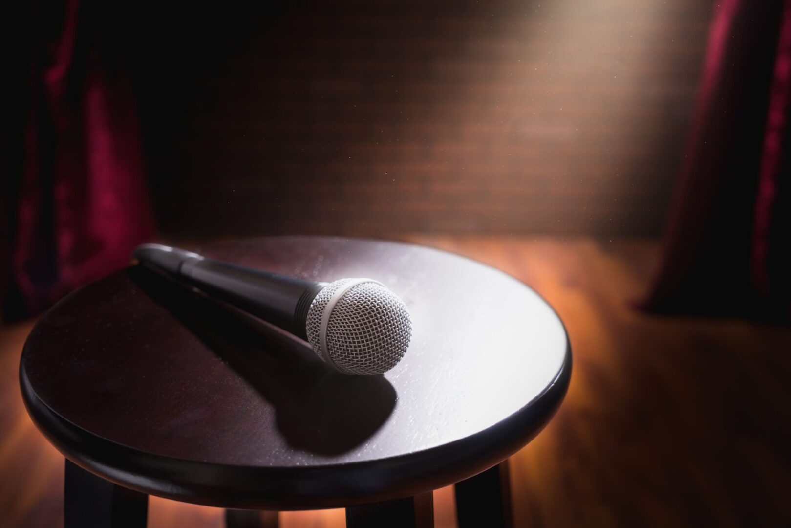 A microphone on top of a wooden table.
