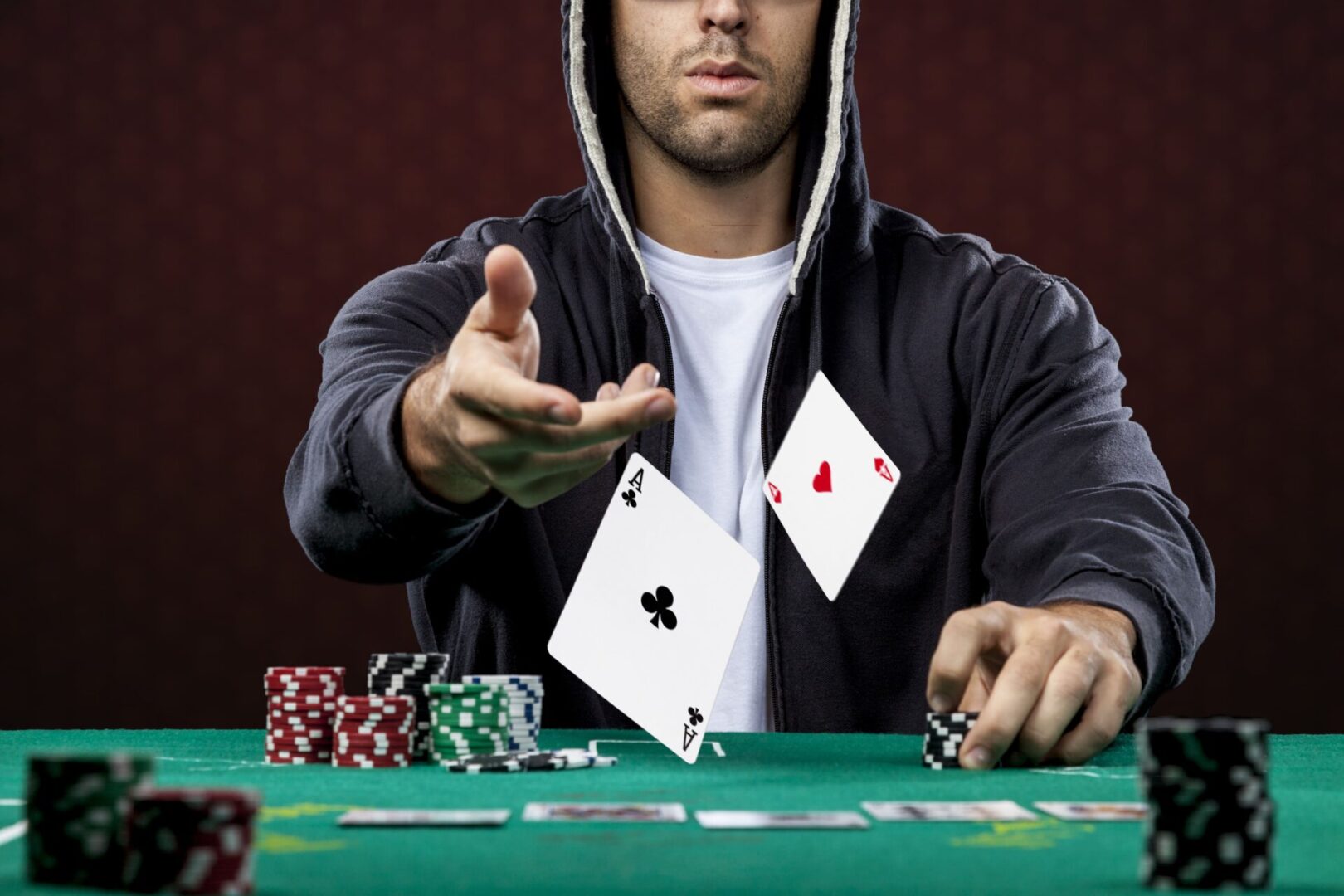 A man in black jacket holding two cards.