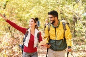 Happy young fit couple trekking outdoors