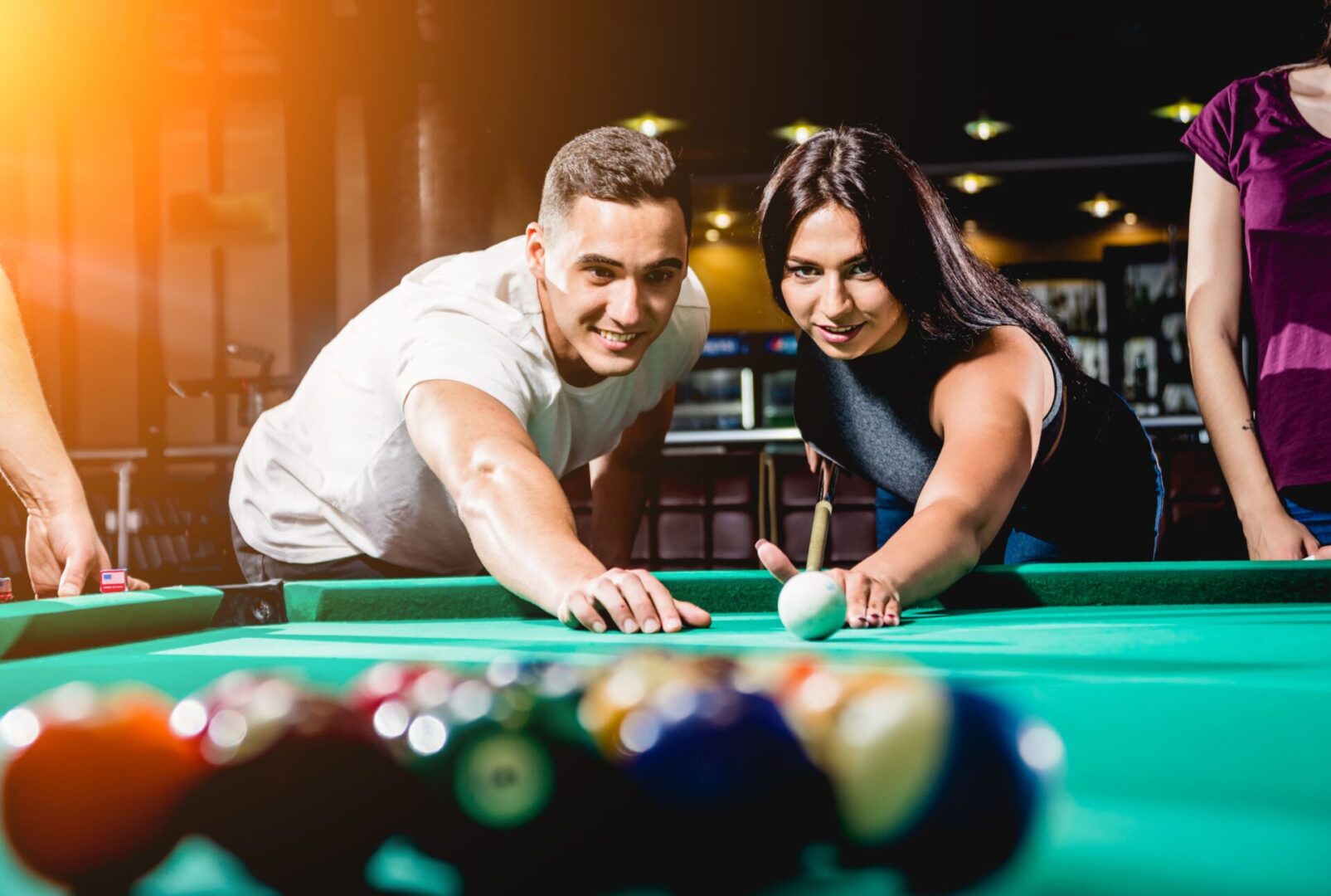 A man and woman playing pool together.