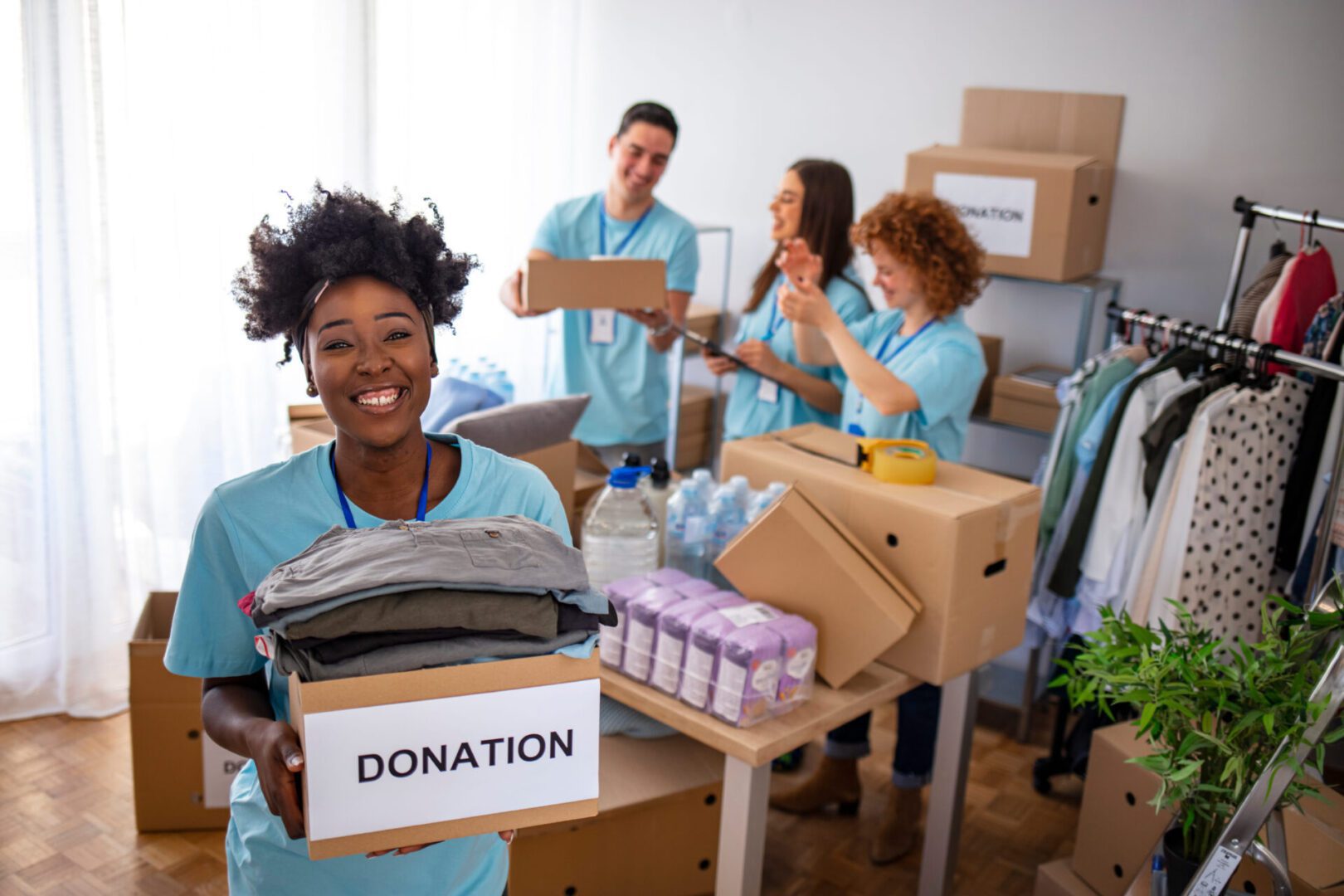 A group of people in blue shirts holding boxes.