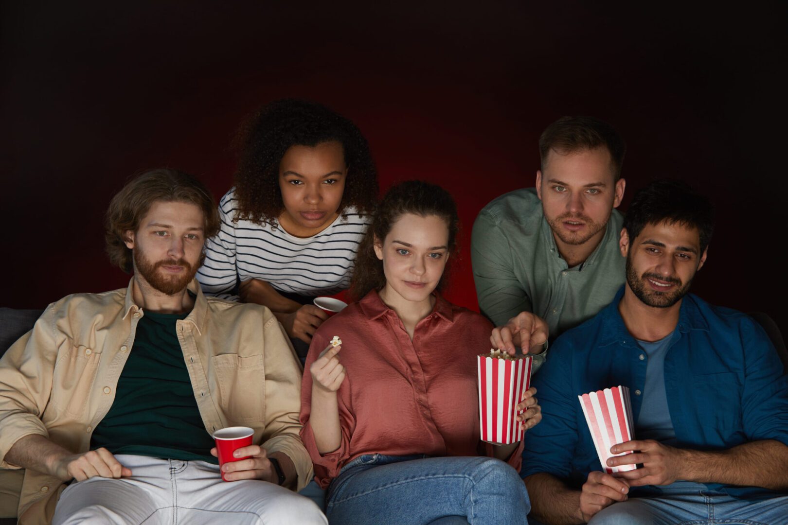 A group of people sitting in front of popcorn.