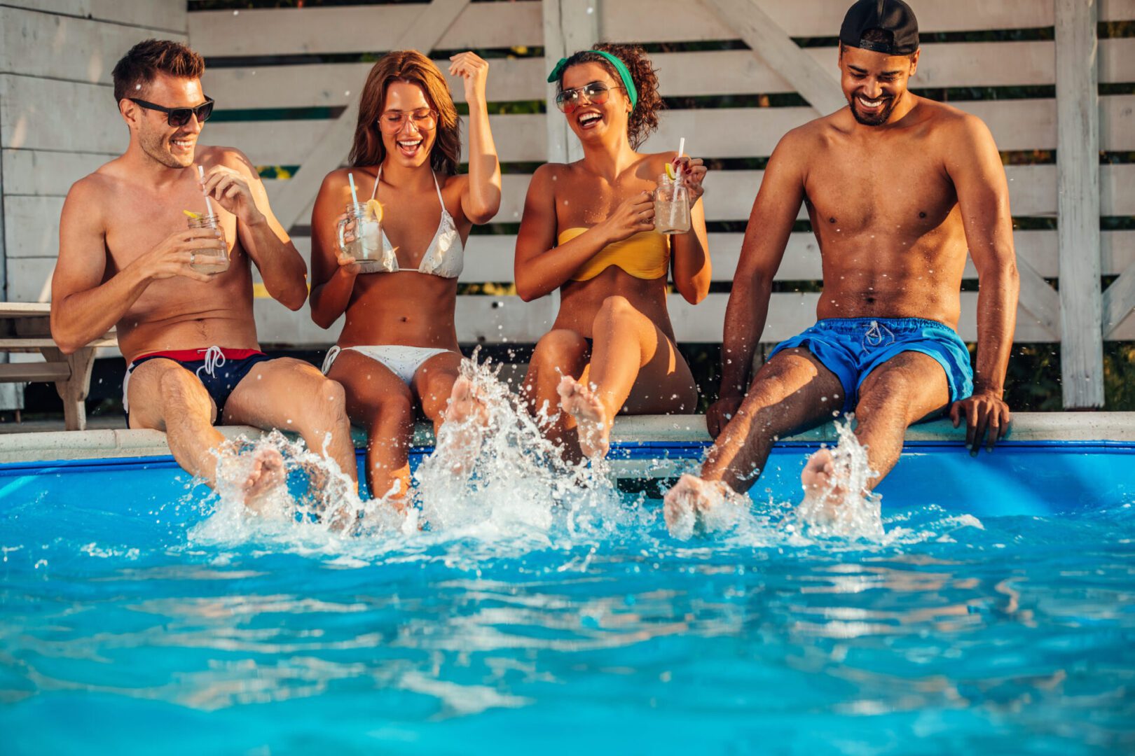 A group of people in the pool with drinks.