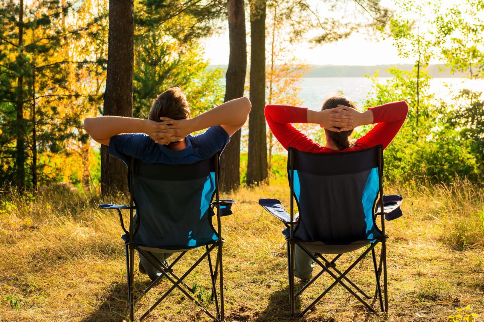 A man and woman sitting in a folding chair.