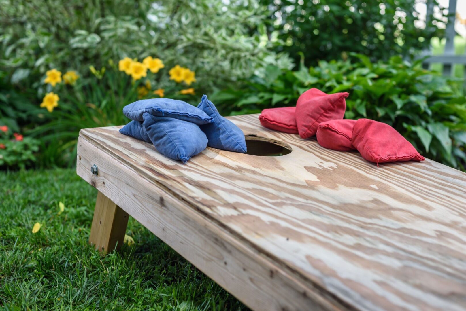 A wooden table with red and blue pillows on it.