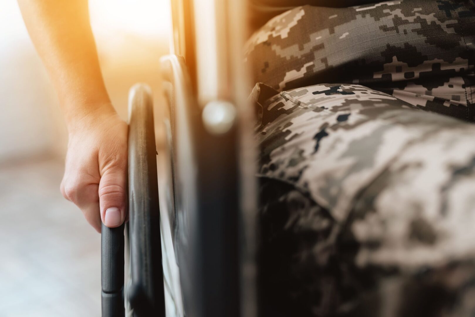 A person in a wheelchair with the sun shining.