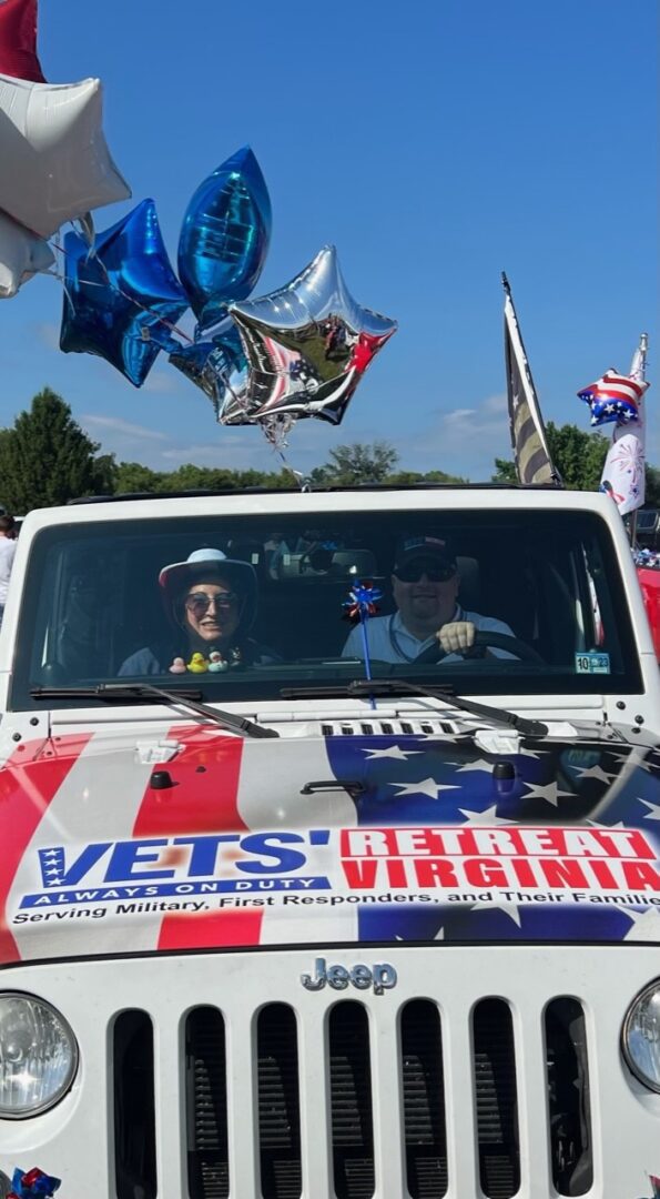A jeep with flags and balloons in the back.