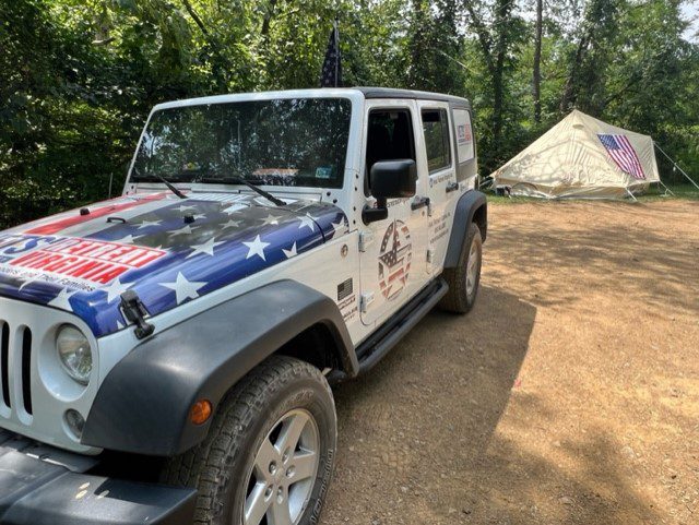 A jeep is parked in front of a tent.