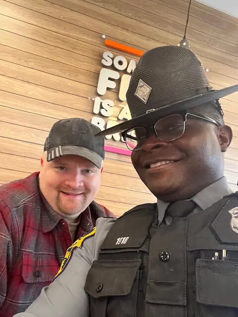 A man and a police officer posing for the camera.