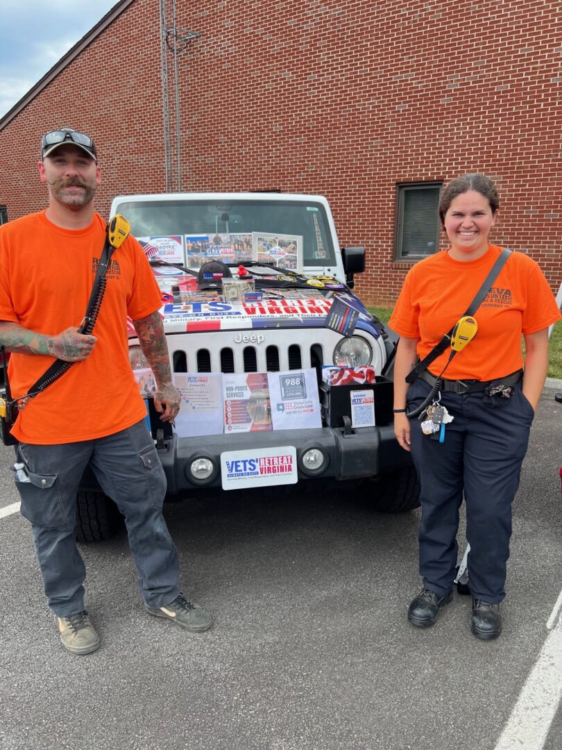 Two people standing by a decorated Jeep.