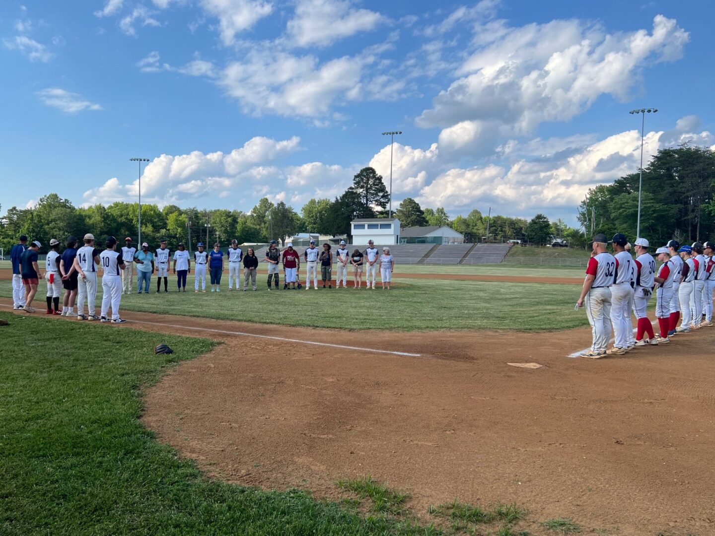 Baseball teams lined up on a field.