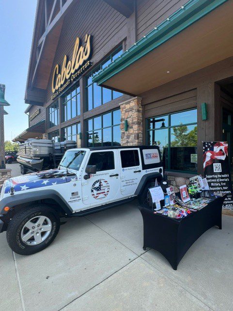 White jeep parked in front of Cabela's store.