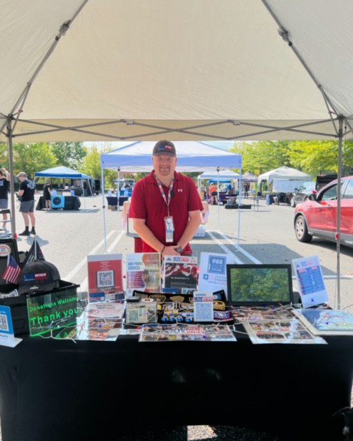 Man at a table selling patriotic items.