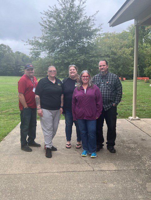 Group of five people standing outside.