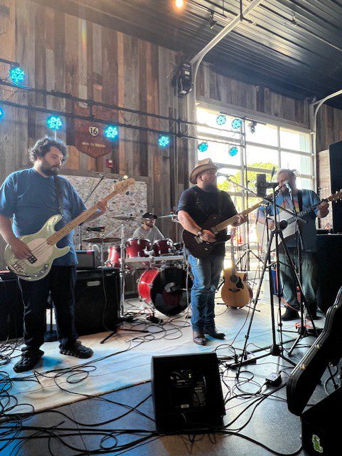 Band playing live on stage with guitars